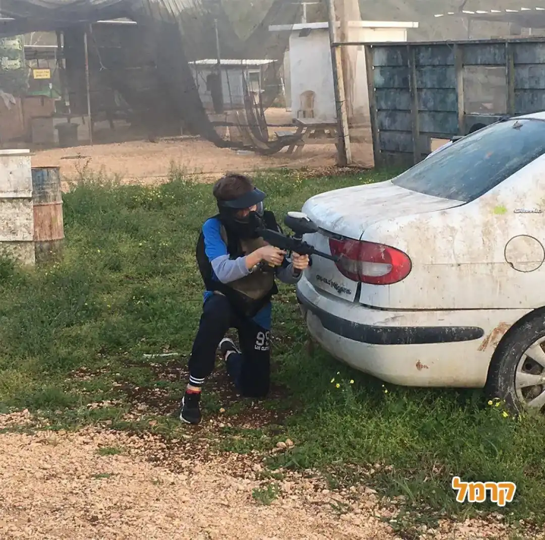 שחקן מסתתר מאחורי רכב