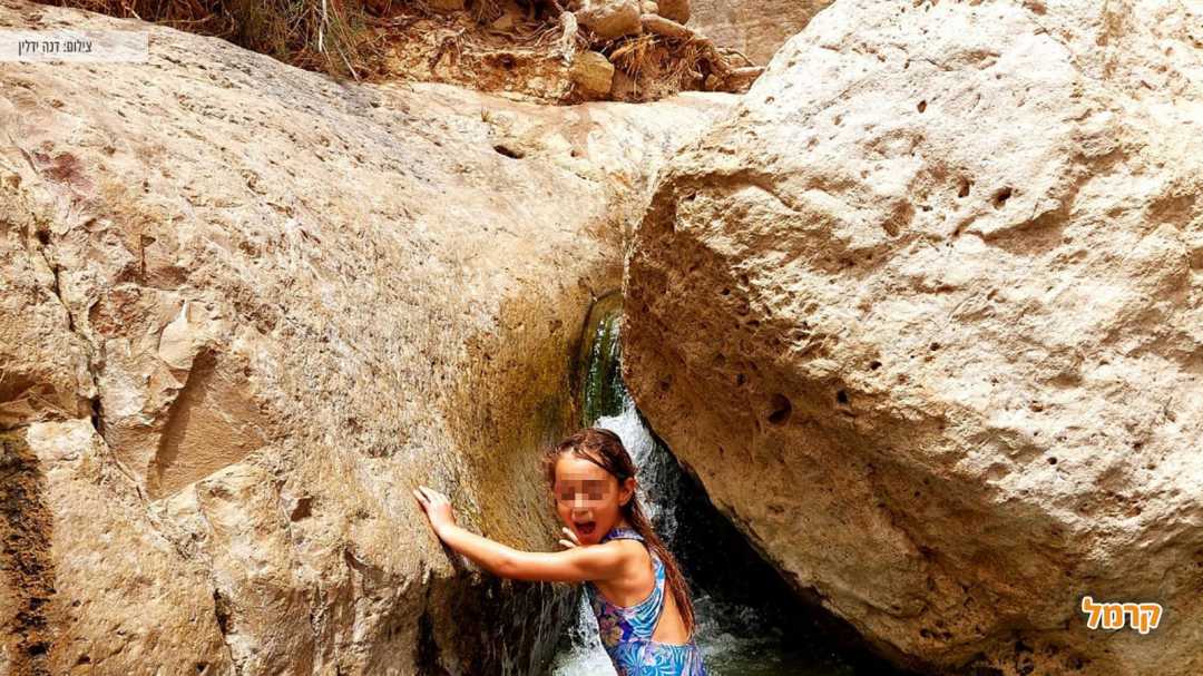 ילדה נהנת ממי הנחל