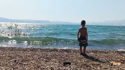 ילד נהנה בחוף ים בכנרת ילד נהנה בחוף ים בכנרת