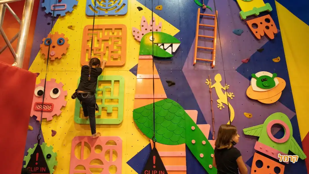 קיר טיפוס עם דינוזאור עליו