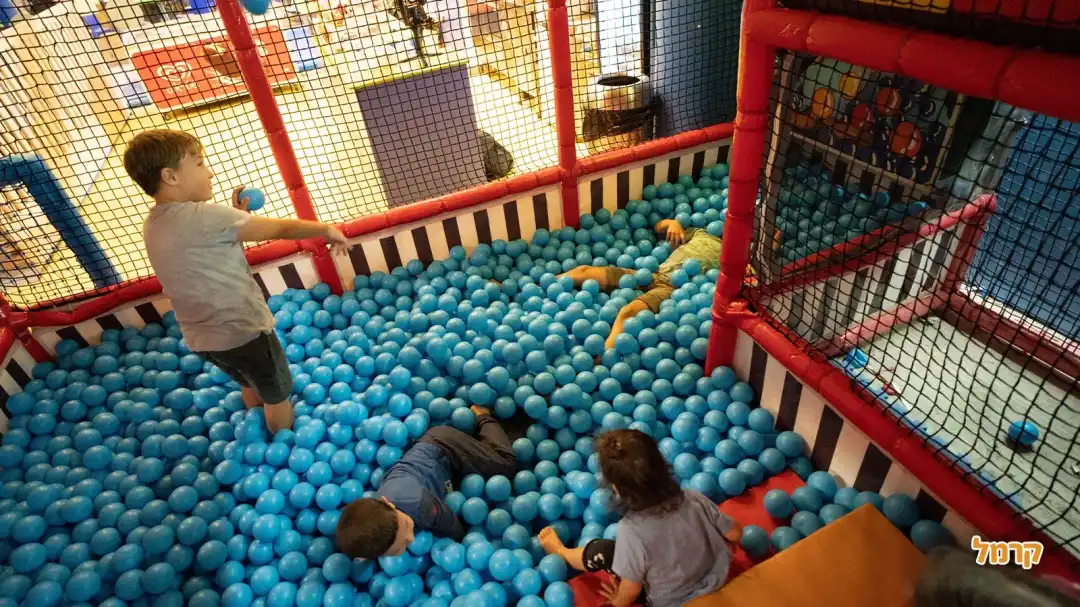 ילדים בבריכת כדורים עם כדורים כחולים רכים