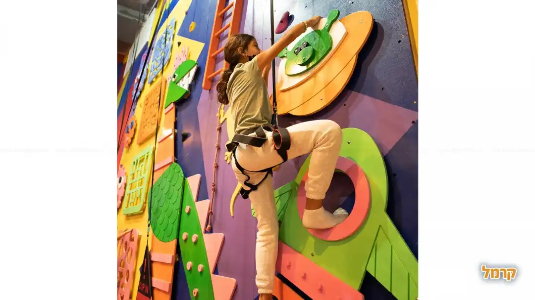 ילדה על קיר טיפוס