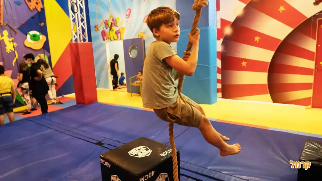 ילד מתנדנד בחבל במסלול נינג'ה