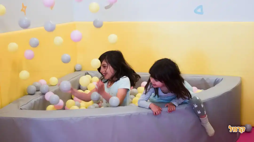 ילדות משחקות בבריכת כדורים