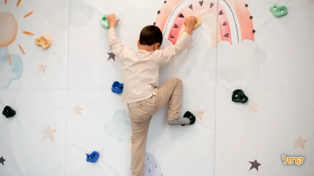 ילד מטפס על קיר הטיפוס