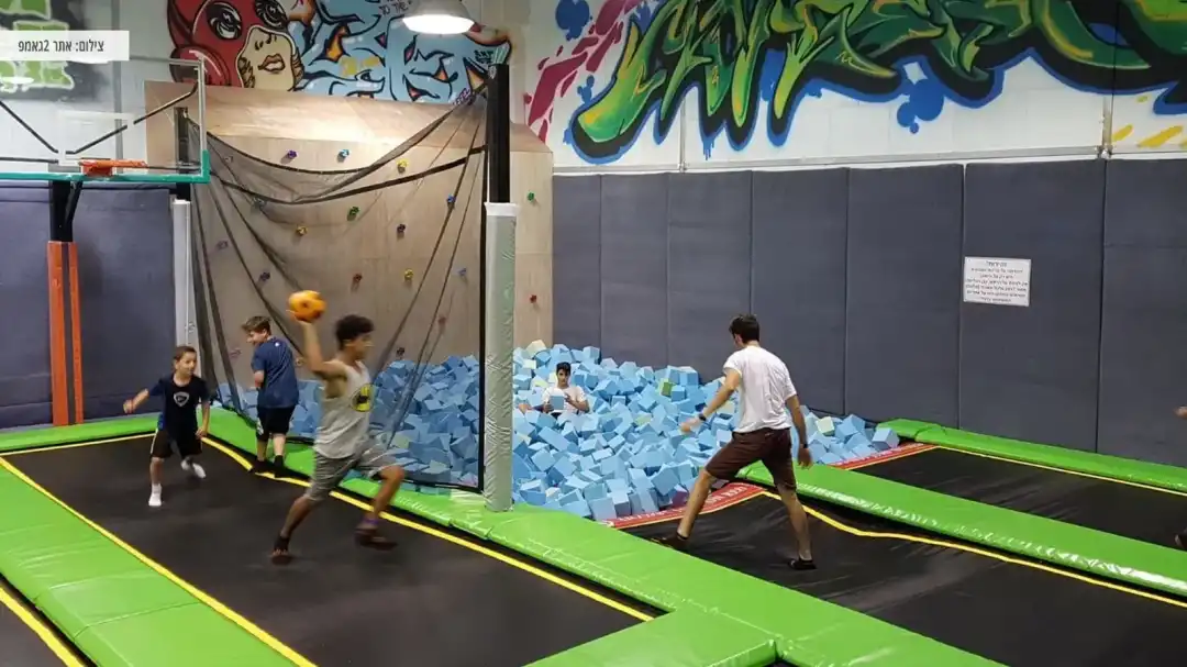 ילדים נהנים עם כדורים בטרמפולינות