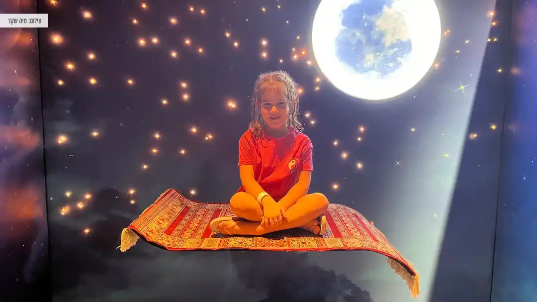 ילדה יושבת על המרבד של אלדין באוויר