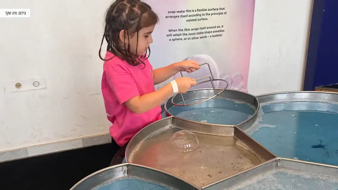 ילדה עושה בועות סבון ענקיות