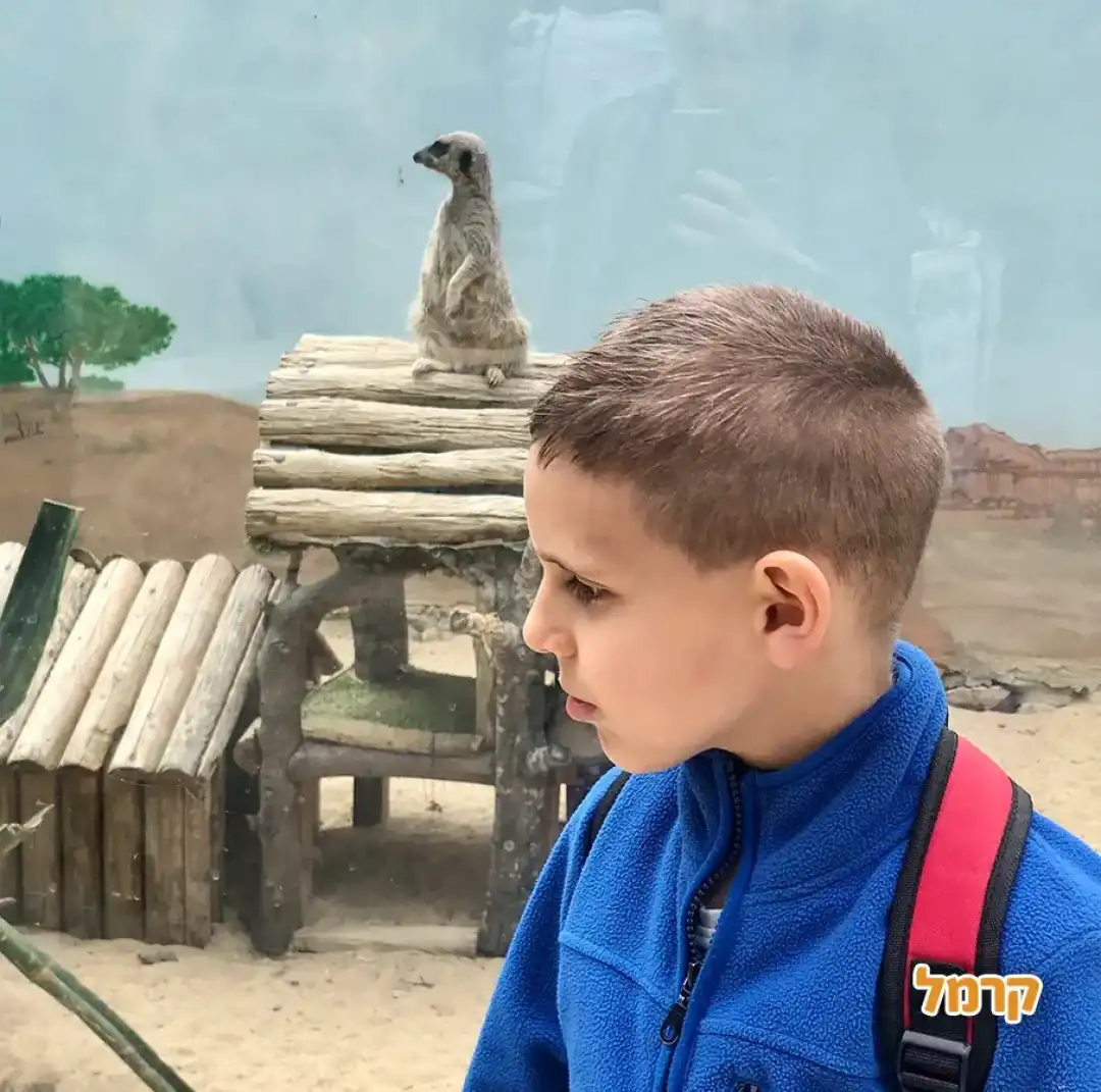 ילד עומד ליד הבית של הלמור